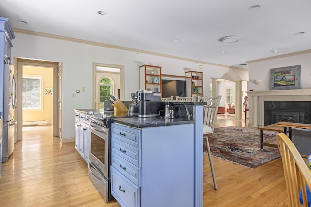 36 Acorn Ln, South Portland, ME 04106 - kitchen featuring a breakfast bar, a baseboard heating unit, arched walkways, appliances with stainless steel finishes, and ornamental molding