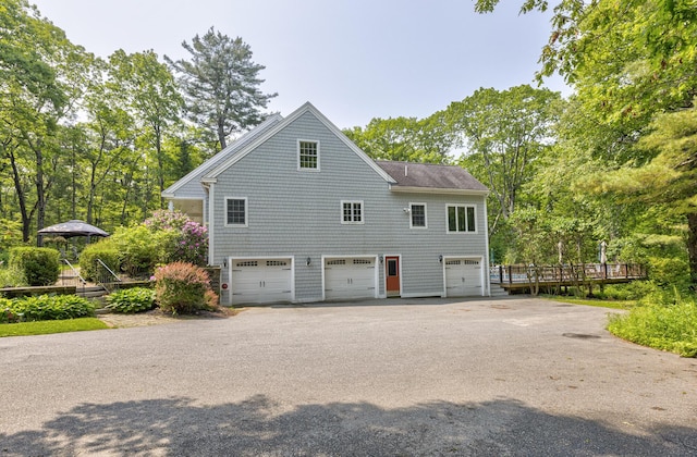 36 Acorn Ln, South Portland, ME 04106 - view of home's exterior with a garage, asphalt driveway, a deck, and view of wooded area