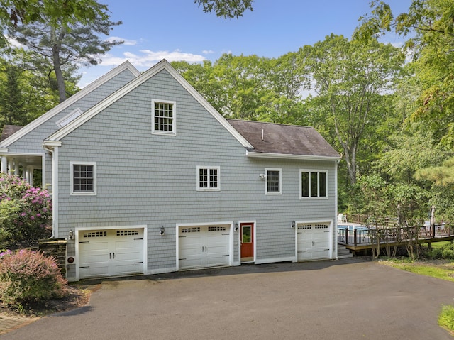 36 Acorn Ln, South Portland, ME 04106 - view of property exterior featuring a shingled roof, a deck, and view of wooded area