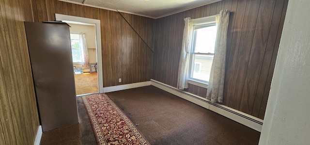 11 Gray St, Waterville, ME 04901 - spare room with a baseboard heating unit, wood walls, dark colored carpet, crown molding, and baseboard heating