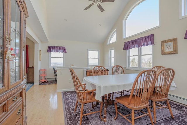 135 Lyle Hall Rd, Wilton, ME 04294 - dining space with high vaulted ceiling, light wood-style floors, a ceiling fan, and baseboards