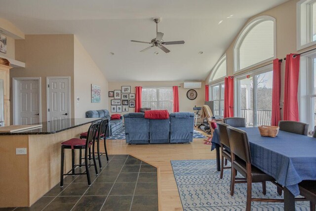 135 Lyle Hall Rd, Wilton, ME 04294 - dining space with high vaulted ceiling, a ceiling fan, a wall mounted AC, and dark wood-type flooring