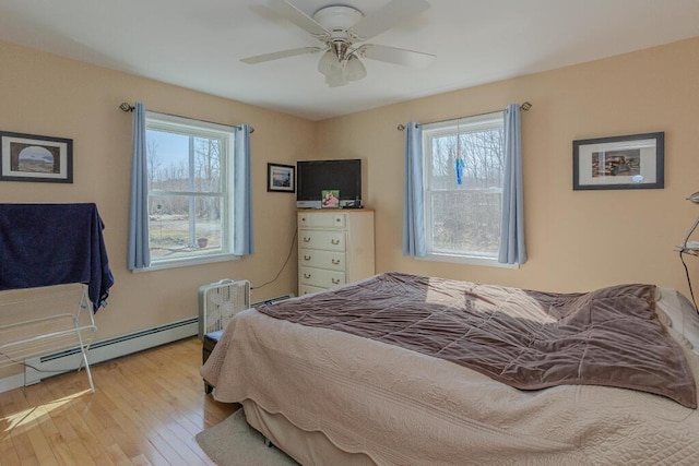135 Lyle Hall Rd, Wilton, ME 04294 - bedroom featuring multiple windows, a baseboard heating unit, hardwood / wood-style flooring, and ceiling fan