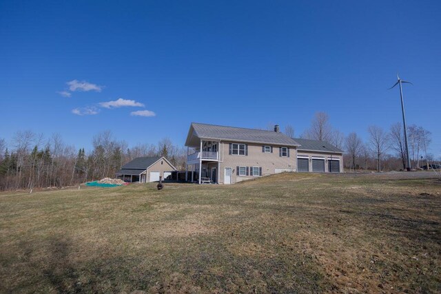 135 Lyle Hall Rd, Wilton, ME 04294 - back of property featuring a garage, a yard, a chimney, and metal roof