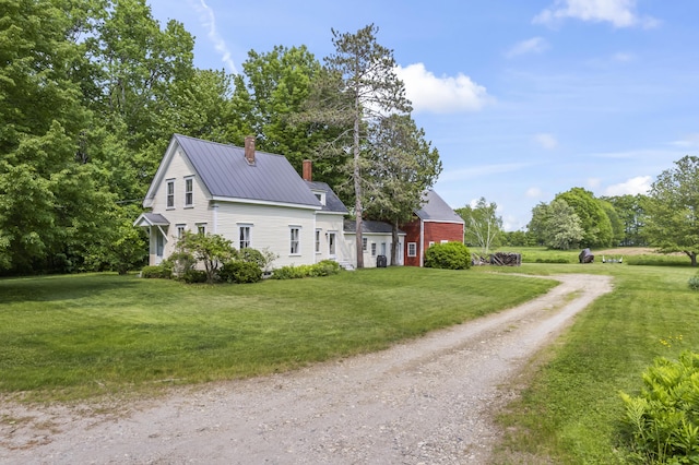 145 Pork Point Rd, Bowdoinham, ME 04008 - view of side of home featuring a chimney, dirt driveway, a lawn, and metal roof