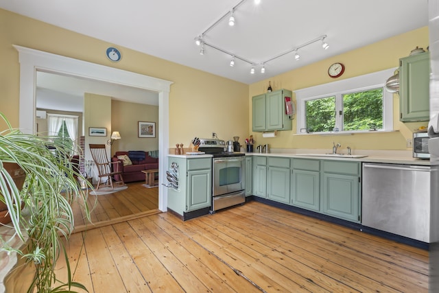145 Pork Point Rd, Bowdoinham, ME 04008 - kitchen with stainless steel appliances, a sink, light countertops, light wood-type flooring, and plenty of natural light