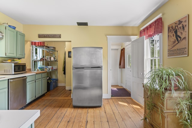 145 Pork Point Rd, Bowdoinham, ME 04008 - kitchen with stainless steel appliances, green cabinets, and healthy amount of natural light