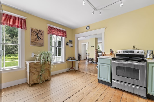 145 Pork Point Rd, Bowdoinham, ME 04008 - kitchen with stainless steel electric range, rail lighting, light countertops, and light wood-type flooring