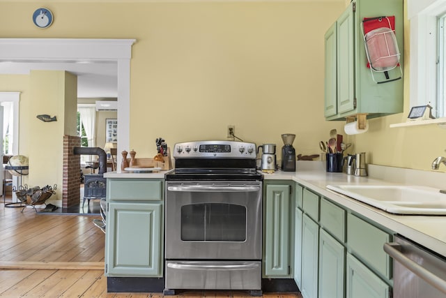 145 Pork Point Rd, Bowdoinham, ME 04008 - kitchen featuring appliances with stainless steel finishes, a sink, light countertops, green cabinetry, and light wood-type flooring
