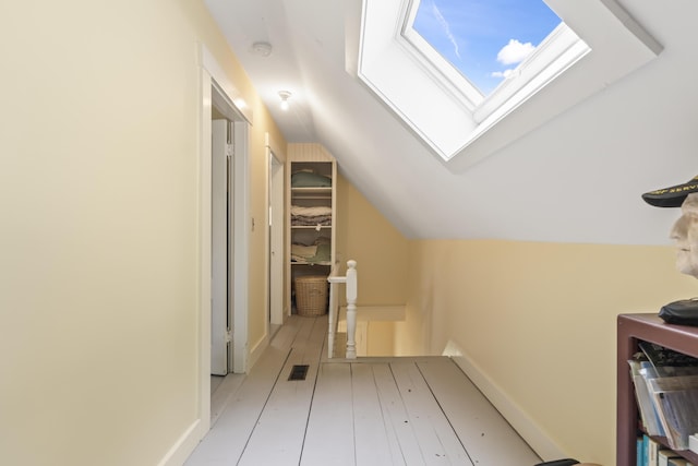 145 Pork Point Rd, Bowdoinham, ME 04008 - hall featuring a skylight, vaulted ceiling, and an upstairs landing