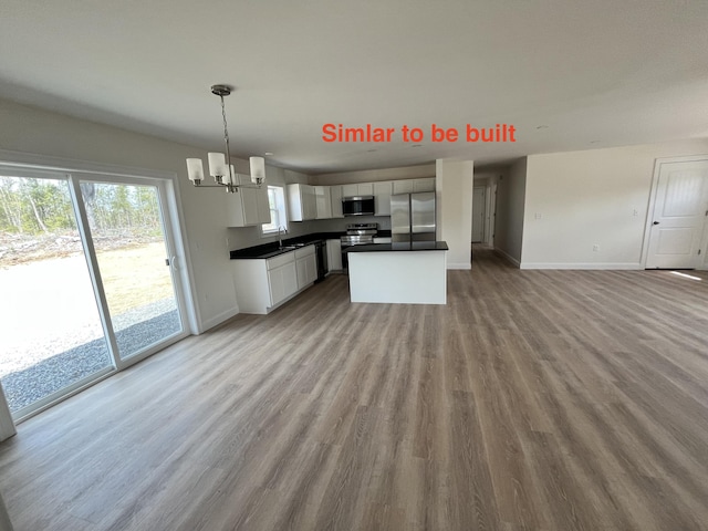 278 Merrill Rd, Levant, ME 04456 - kitchen featuring stainless steel appliances, open floor plan, white cabinetry, wood finished floors, and dark countertops