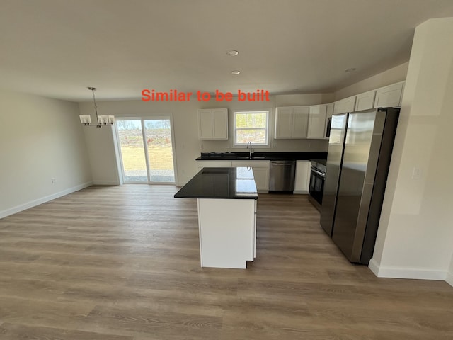 278 Merrill Rd, Levant, ME 04456 - kitchen with stainless steel appliances, dark countertops, white cabinets, a chandelier, and healthy amount of natural light