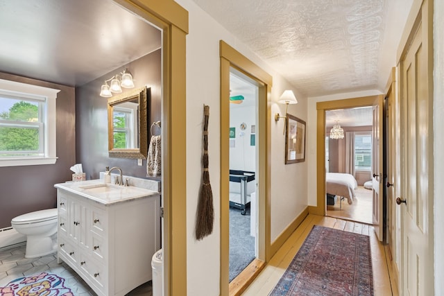 47 Beal St, Norway, ME 04268 - ensuite bathroom with toilet, vanity, a chandelier, a textured ceiling, and baseboards