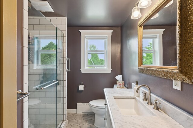 47 Beal St, Norway, ME 04268 - bathroom with toilet, baseboard heating, vanity, a shower stall, and tile patterned flooring