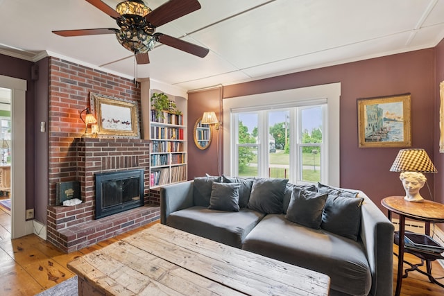 47 Beal St, Norway, ME 04268 - living area with hardwood / wood-style floors, ornamental molding, a ceiling fan, and a brick fireplace