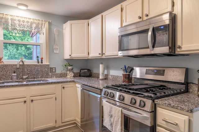 44 Cortland Cir Unit 44, Bangor, ME 04401 - kitchen featuring appliances with stainless steel finishes, dark stone counters, and white cabinetry