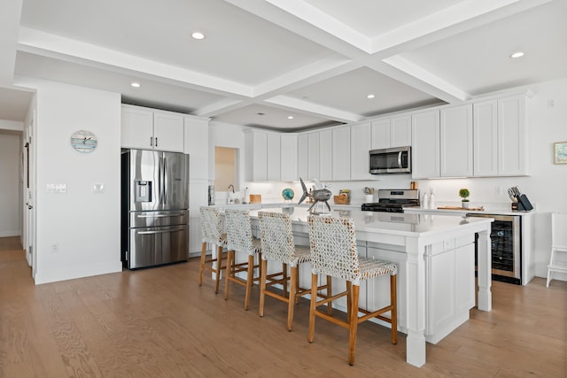 218 Washington Ave Unit 401, Portland, ME 04101 - kitchen featuring appliances with stainless steel finishes, wine cooler, coffered ceiling, beam ceiling, and light wood finished floors