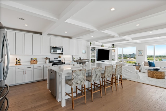 218 Washington Ave Unit 401, Portland, ME 04101 - kitchen with open floor plan, appliances with stainless steel finishes, coffered ceiling, light wood-style flooring, and beam ceiling