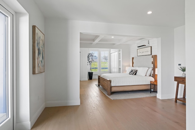 218 Washington Ave Unit 401, Portland, ME 04101 - bedroom with a wall unit AC, wood finished floors, beam ceiling, recessed lighting, and coffered ceiling