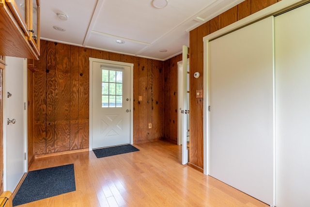 369 Grove St, Lewiston, ME 04240 - doorway to outside featuring light wood-style flooring, a baseboard heating unit, wooden walls, and baseboards