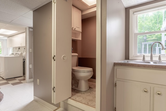 369 Grove St, Lewiston, ME 04240 - bathroom with independent washer and dryer, tile patterned floors, toilet, and plenty of natural light