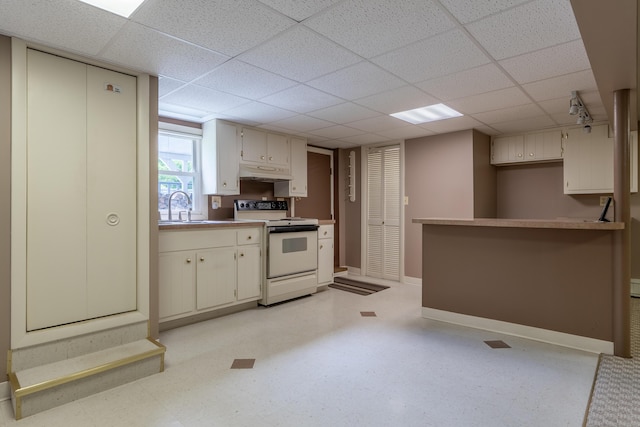 369 Grove St, Lewiston, ME 04240 - kitchen featuring white range with electric stovetop, under cabinet range hood, a drop ceiling, baseboards, and a sink