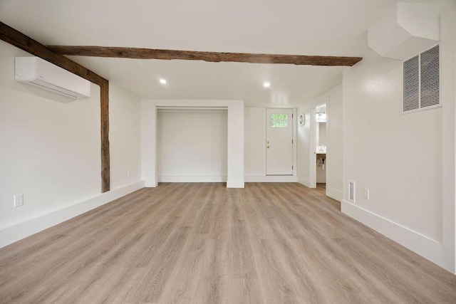 427 Haley Rd, Kittery, ME 03905 - unfurnished living room with a wall mounted AC, beam ceiling, light wood finished floors, recessed lighting, and baseboards