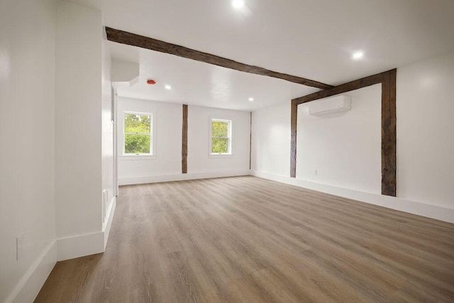 427 Haley Rd, Kittery, ME 03905 - unfurnished living room featuring a wall unit AC, wood finished floors, beamed ceiling, recessed lighting, and baseboards