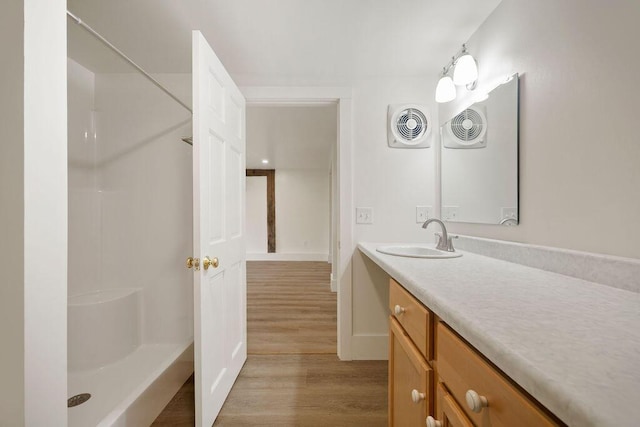 427 Haley Rd, Kittery, ME 03905 - bathroom featuring wood finished floors, vanity, a shower, and baseboards