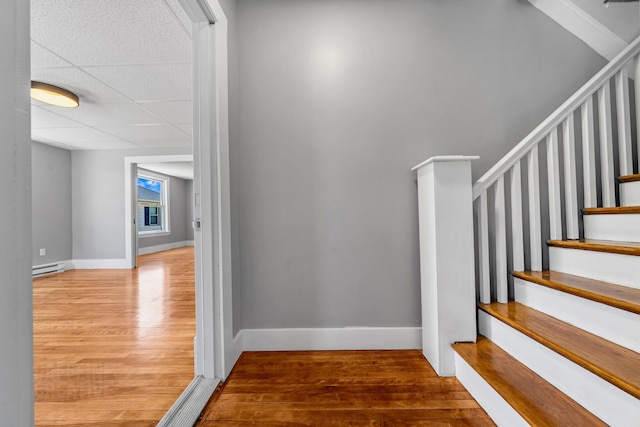 181 Webster St, Lewiston, ME 04240 - stairs featuring wood finished floors, baseboards, a baseboard heating unit, and a drop ceiling