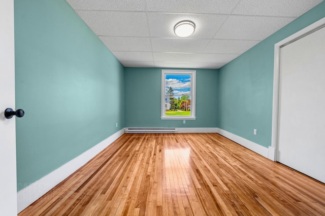 181 Webster St, Lewiston, ME 04240 - unfurnished room with baseboard heating, a drop ceiling, hardwood / wood-style flooring, and baseboards