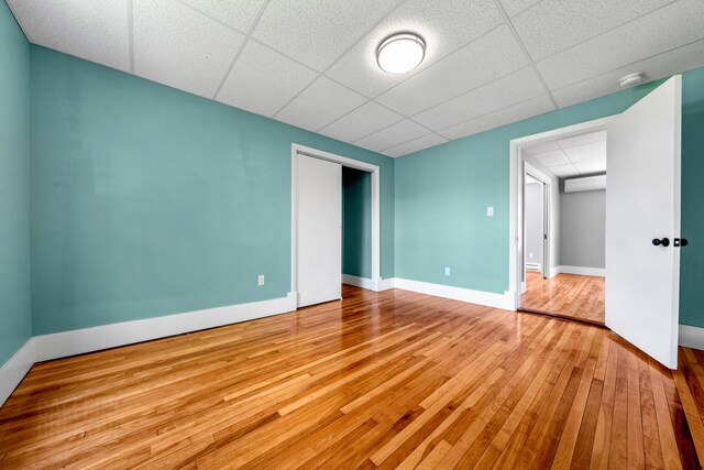 181 Webster St, Lewiston, ME 04240 - unfurnished bedroom with wood-type flooring, a paneled ceiling, a closet, and baseboards