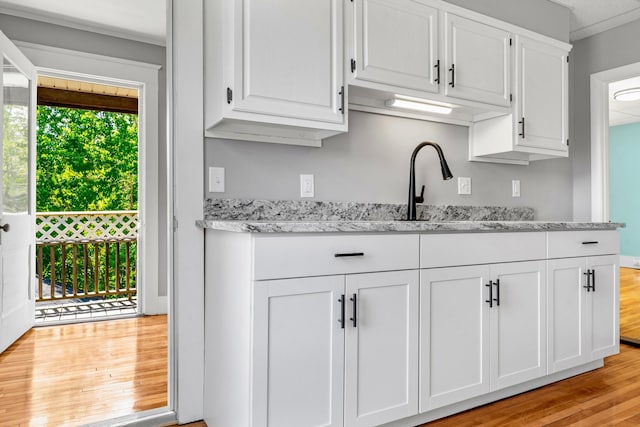 181 Webster St, Lewiston, ME 04240 - kitchen with white cabinets, light wood-type flooring, and light stone counters