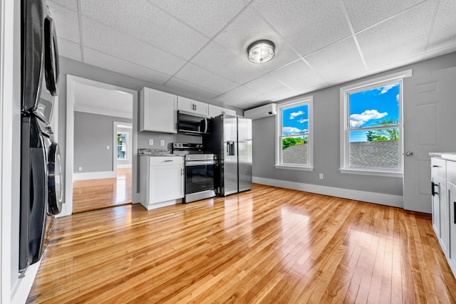 181 Webster St, Lewiston, ME 04240 - kitchen with appliances with stainless steel finishes, a drop ceiling, light wood-style floors, baseboards, and white cabinets