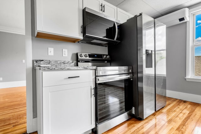 181 Webster St, Lewiston, ME 04240 - kitchen with appliances with stainless steel finishes, baseboards, light wood-style flooring, white cabinets, and light stone counters