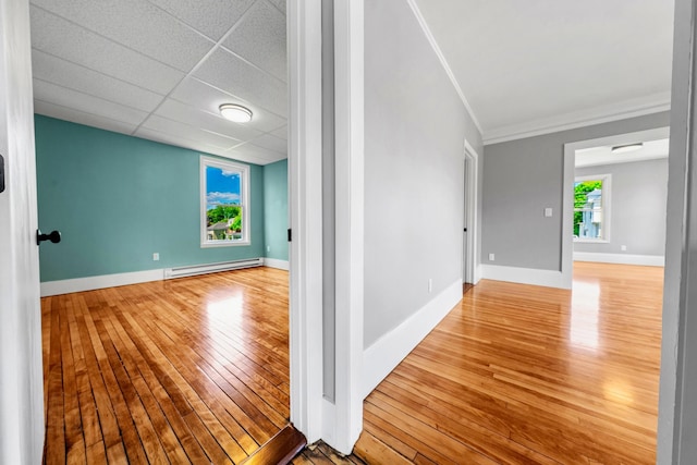 181 Webster St, Lewiston, ME 04240 - empty room featuring baseboard heating, hardwood / wood-style floors, crown molding, baseboards, and a drop ceiling