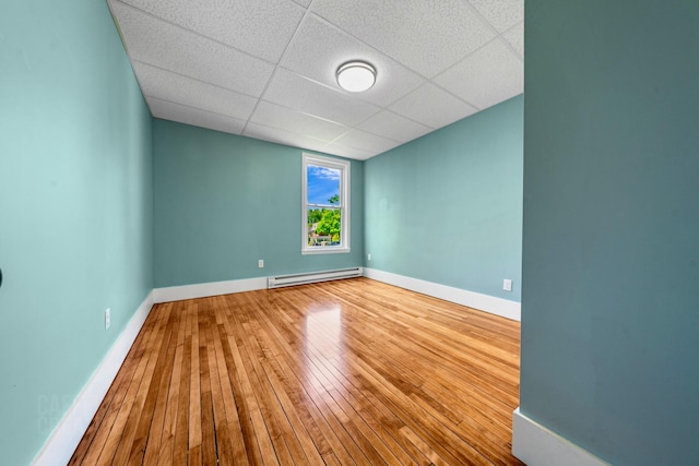 181 Webster St, Lewiston, ME 04240 - spare room with a baseboard radiator, a paneled ceiling, hardwood / wood-style flooring, and baseboards