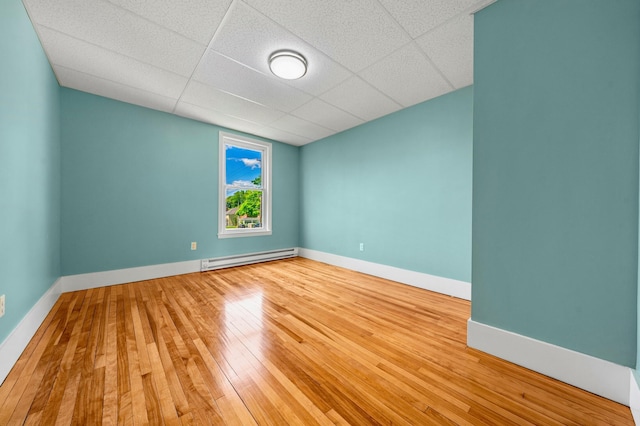 181 Webster St, Lewiston, ME 04240 - empty room with a baseboard heating unit, hardwood / wood-style floors, baseboards, and a paneled ceiling