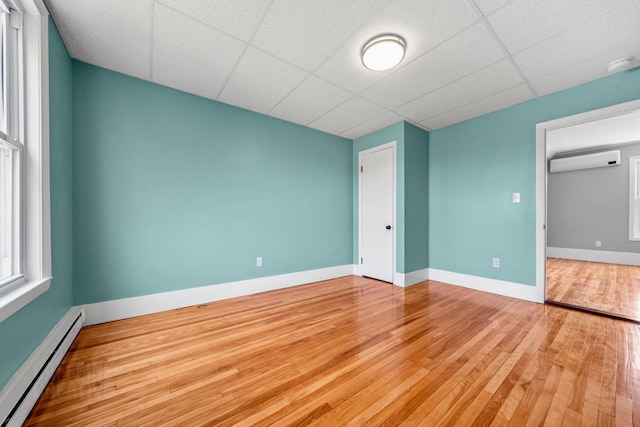 181 Webster St, Lewiston, ME 04240 - empty room with a baseboard radiator, a wall mounted air conditioner, wood finished floors, a smoke detector, and baseboards