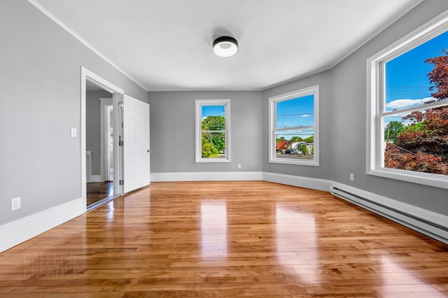 181 Webster St, Lewiston, ME 04240 - spare room with wood finished floors, baseboard heating, baseboards, and ornamental molding