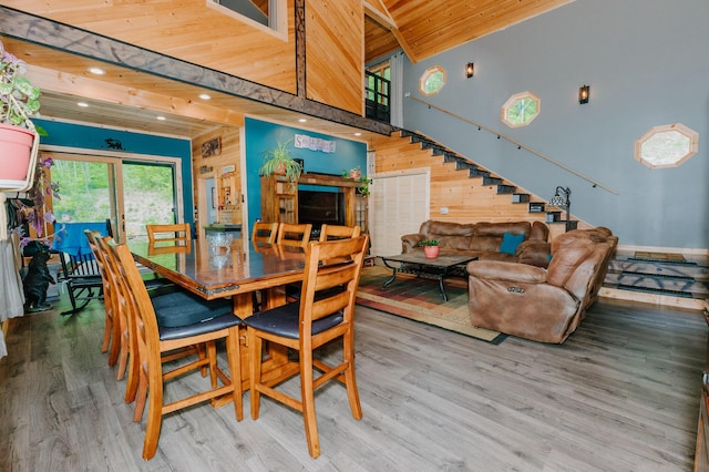 15 Doe Cir, Bingham, ME 04920 - dining area featuring wooden ceiling with exposed beams, wood finished floors, stairs, a high ceiling, and wooden walls
