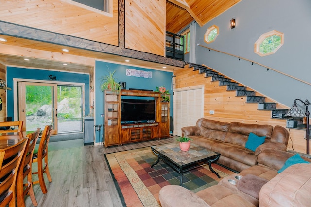 15 Doe Cir, Bingham, ME 04920 - living area featuring wooden ceiling with exposed beams, wood finished floors, wood walls, a high ceiling, and stairway