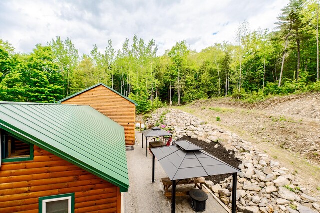 15 Doe Cir, Bingham, ME 04920 - view of property exterior with a gazebo, log veneer siding, and metal roof