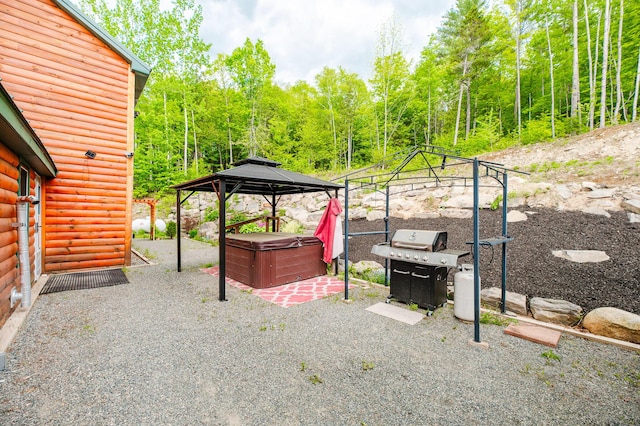 15 Doe Cir, Bingham, ME 04920 - view of patio / terrace with a hot tub, a gazebo, grilling area, and a forest view