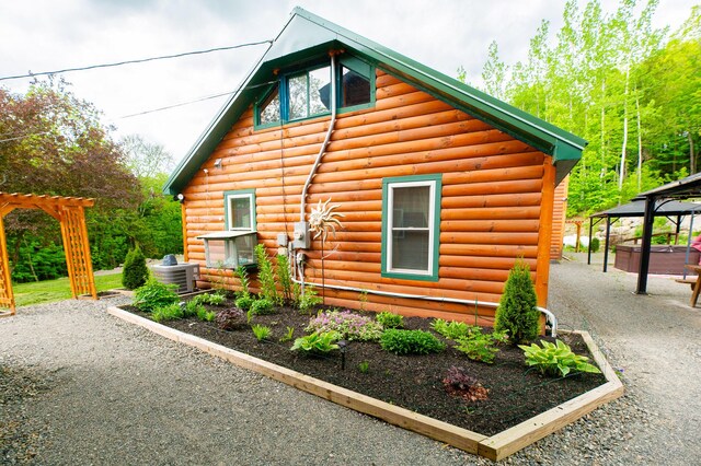 15 Doe Cir, Bingham, ME 04920 - view of home's exterior with central air condition unit, faux log siding, and a gazebo