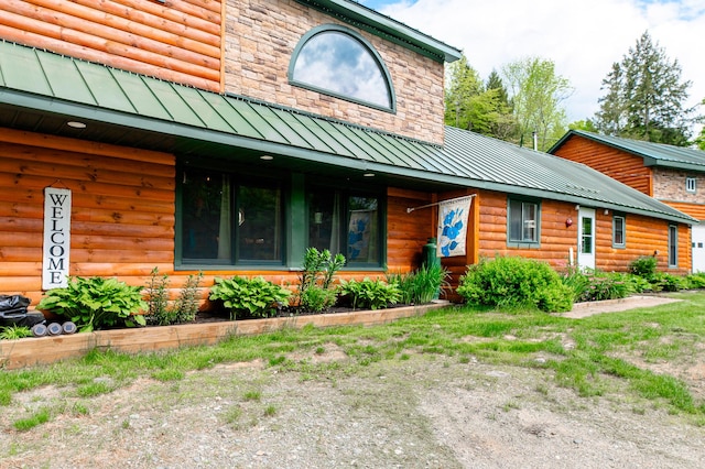 15 Doe Cir, Bingham, ME 04920 - view of front of house with a standing seam roof, faux log siding, and metal roof