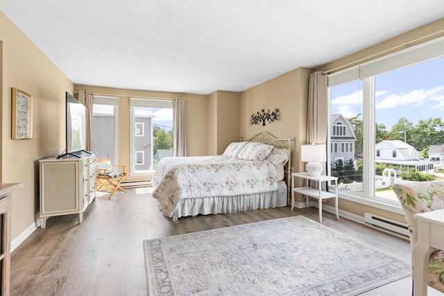 1 Seacliff Ave Unit 3D, Old Orchard Beach, ME 04064 - bedroom featuring a baseboard heating unit, multiple windows, and wood finished floors