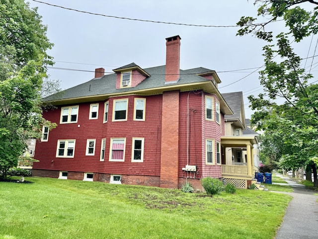 91 Washburn Ave, Portland, ME 04102 - view of home's exterior with a chimney, a yard, and roof with shingles