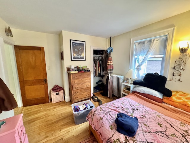 91 Washburn Ave, Portland, ME 04102 - bedroom with radiator heating unit, light wood-type flooring, and a closet