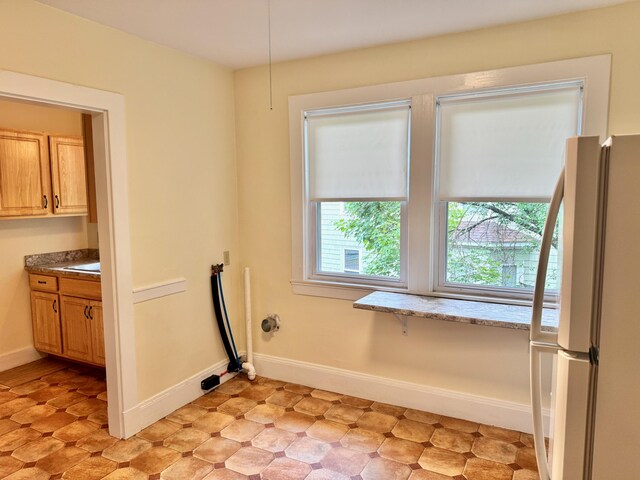 91 Washburn Ave, Portland, ME 04102 - laundry room featuring baseboards, light flooring, and a sink